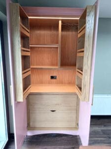 empty kitchen larder showing integrated lighting, shelves and wine glass holders.